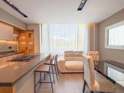 a kitchen and living room with a counter and a couch at Apartamento de lujo a 3 minutos del Aeropuerto JMC 102 in Rionegro