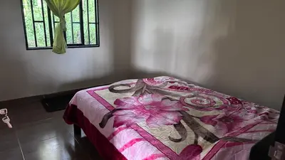 a bedroom with a bed with a pink blanket and a window at Finca La Preciosura in El Peñol