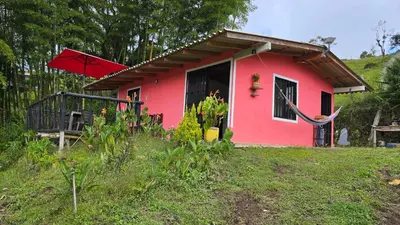a small red house with a red umbrella at Finca La Preciosura in El Peñol