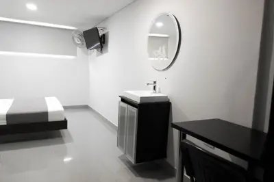 a white bathroom with a sink and a mirror at 3H hotel centro histórico in Medellín