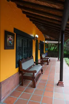 two benches sitting on a porch of a house at Portofino mountain retreat near Medellín in Envigado