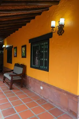 an orange wall with a bench and a window at Portofino mountain retreat near Medellín in Envigado