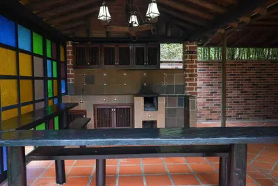 a large wooden table in a kitchen with stained glass windows at Portofino mountain retreat near Medellín in Envigado