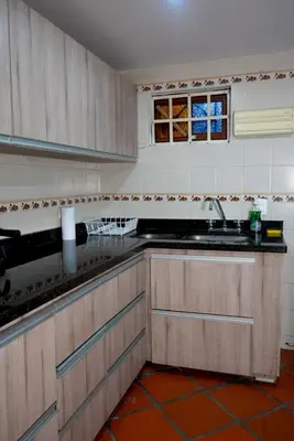 a kitchen with wooden cabinets and a sink and a window at Portofino mountain retreat near Medellín in Envigado