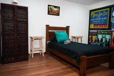a bedroom with a bed with a blue pillow and two tables at Portofino mountain retreat near Medellín in Envigado