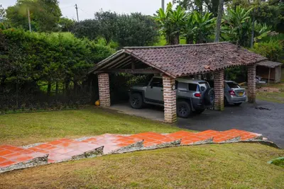 a garage with a car parked in a yard at Portofino mountain retreat near Medellín in Envigado