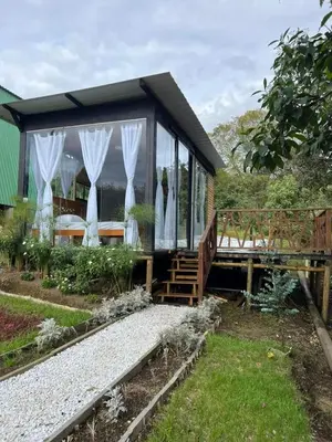 a house with white curtains on the side of it at Pazionart Chalets in Santa Elena