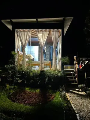a house with curtains in the yard at night at Pazionart Chalets in Santa Elena