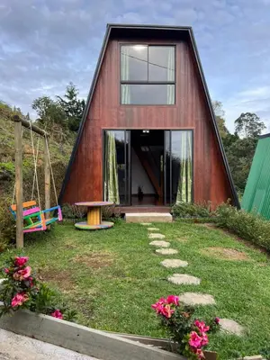 a house shaped like a triangle with a yard at Pazionart Chalets in Santa Elena