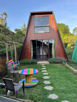 a small house with a table and chairs in the yard at Pazionart Chalets in Santa Elena