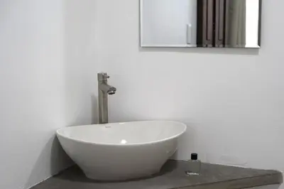 a bathroom with a white bowl sink and a mirror at El Cortijo