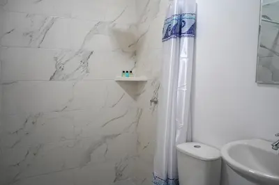 a white bathroom with a shower curtain and a toilet at El Cortijo