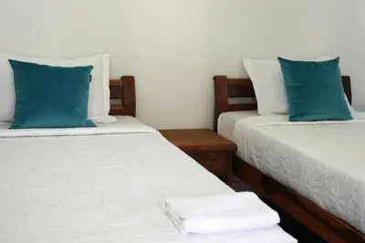 two beds with blue and white pillows in a room at El Cortijo