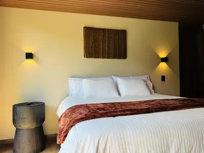 a bedroom with a large bed with white sheets and pillows at Exclusive Villa - Lake View - Forest in La Pradera