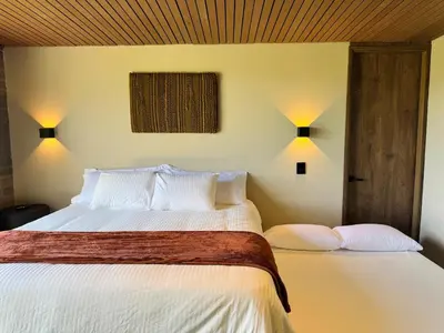 a bedroom with a white bed with two pillows at Exclusive Villa - Lake View - Forest in La Pradera