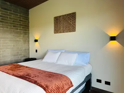 a bedroom with a bed and two lights on the wall at Exclusive Villa - Lake View - Forest in La Pradera