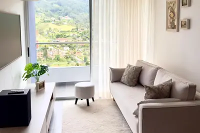 a living room with a couch and a large window at Apartamento completo en Sabaneta in Sabaneta