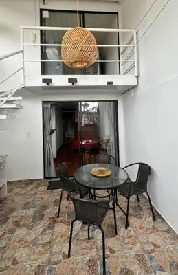 a table and chairs in a room with a balcony at Dúplex familiar cerca al Cable y Milán con patio in Manizales
