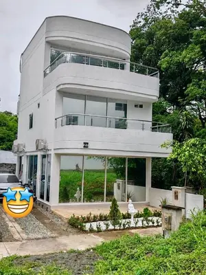 a large white house with a car parked in front of it at Nautica Resort in Sopetran