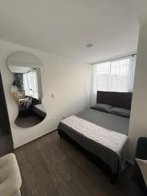 a bedroom with a bed and a mirror at Simplemente en Casa! in Manizales