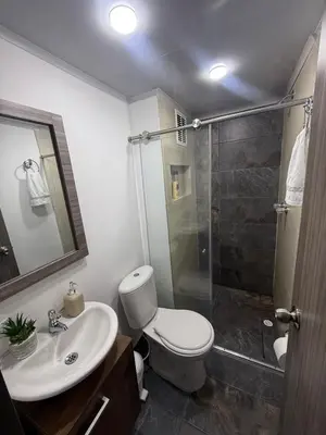 a bathroom with a toilet and a sink and a shower at Simplemente en Casa! in Manizales