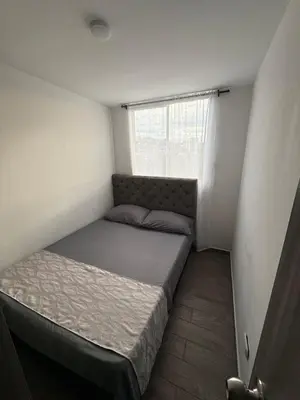 a small bedroom with a bed and a window at Simplemente en Casa! in Manizales