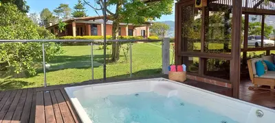 a hot tub on a deck next to a house at Casa de Campo Bheta in Guatapé
