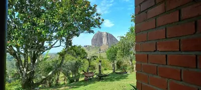 a view of a rock in the distance from a brick wall at Casa de Campo Bheta in Guatapé