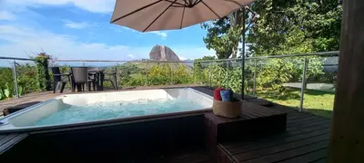 a hot tub on a deck with an umbrella at Casa de Campo Bheta in Guatapé