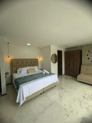 a bedroom with a large bed and a couch at Faro 201, 202, 203 Lujo en Laureles Ubicación Premium in Medellín