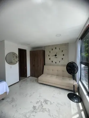 a living room with a couch and a clock on the wall at Faro 201, 202, 203 Lujo en Laureles Ubicación Premium in Medellín