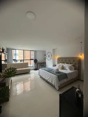 a large white bedroom with a bed and a couch at Faro 201, 202, 203 Lujo en Laureles Ubicación Premium in Medellín