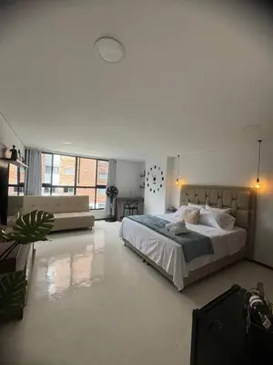 a large white bedroom with a bed and a couch at Faro 201, 202, 203 Lujo en Laureles Ubicación Premium in Medellín