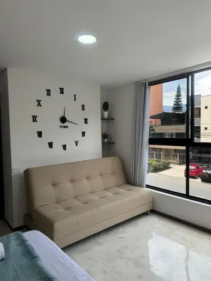a living room with a couch and a clock on the wall at 22 Comfort and style in Medellín Laureles in Medellín