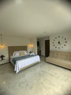 a bedroom with a bed and a clock on the wall at 22 Comfort and style in Medellín Laureles in Medellín