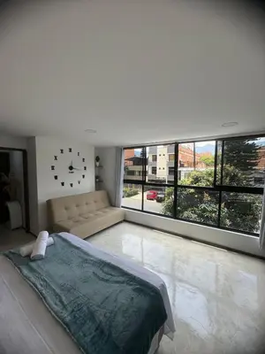 a bedroom with a bed and a couch and a large window at 22 Comfort and style in Medellín Laureles in Medellín
