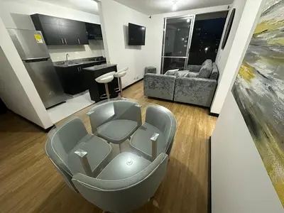 a living room with a couch and a kitchen at Hermoso apartamento amoblado Sabaneta1309 in Sabaneta