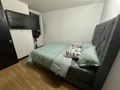 a bedroom with a bed and a flat screen tv at Hermoso apartamento amoblado Sabaneta1309 in Sabaneta