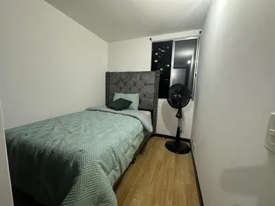 a bedroom with a bed and a fan next to a window at Hermoso apartamento amoblado Sabaneta1309 in Sabaneta