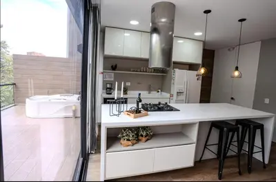 a kitchen with a sink and a counter with stools at Energy Living - Luxury Apartment with Jacuzzi and Private Terrace in Medellín