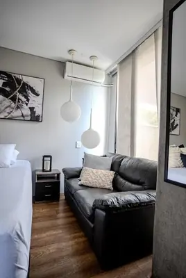a living room with a black leather couch and a window at Energy Living - Luxury Apartment with Jacuzzi and Private Terrace in Medellín