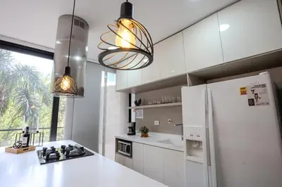 a kitchen with white cabinets and a white refrigerator at Energy Living - Luxury Apartment with Jacuzzi and Private Terrace in Medellín