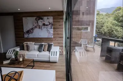 a living room with a white couch and a large window at Energy Living - Luxury Apartment with Jacuzzi and Private Terrace in Medellín
