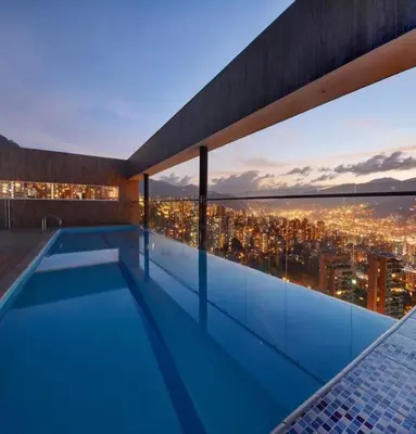 a swimming pool on the roof of a building with a city skyline at Energy Living - Luxury Apartment with Jacuzzi and Private Terrace in Medellín