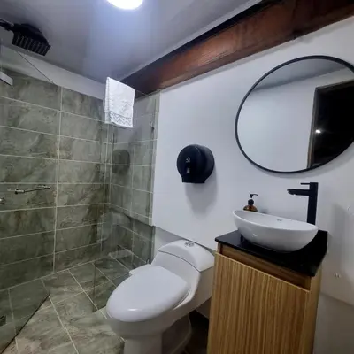 a bathroom with a toilet and a sink and a mirror at Casa solare in Medellín