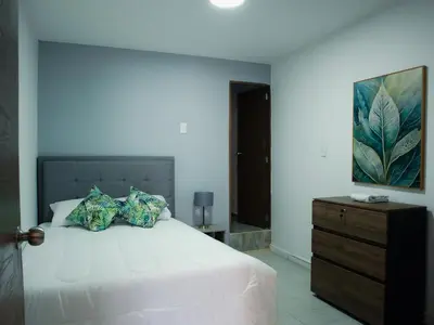 a bedroom with a bed with a dresser and a painting at Casa solare in Medellín