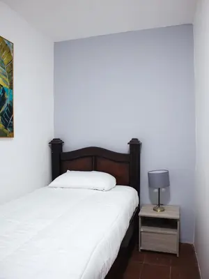 a bedroom with a bed and a table with a lamp at Casa solare in Medellín