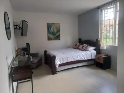 a bedroom with a bed and a chair in it at Casa solare in Medellín