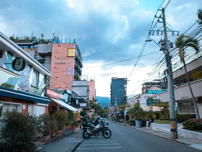 a person riding a motorcycle down a city street at Casa solare in Medellín