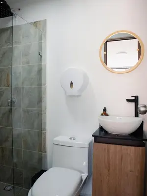 a bathroom with a toilet and a sink and a mirror at Casa solare in Medellín
